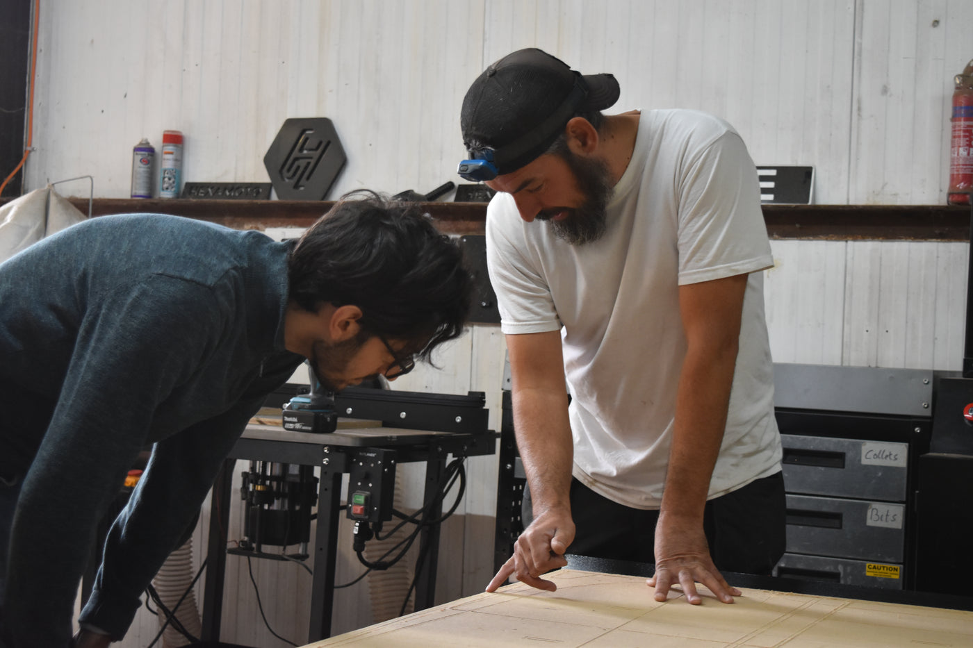Two men working together on a project in a workshop setting.
