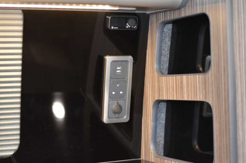 Campervan electrical sockets and heater controller fitted on a black acrylic splashback