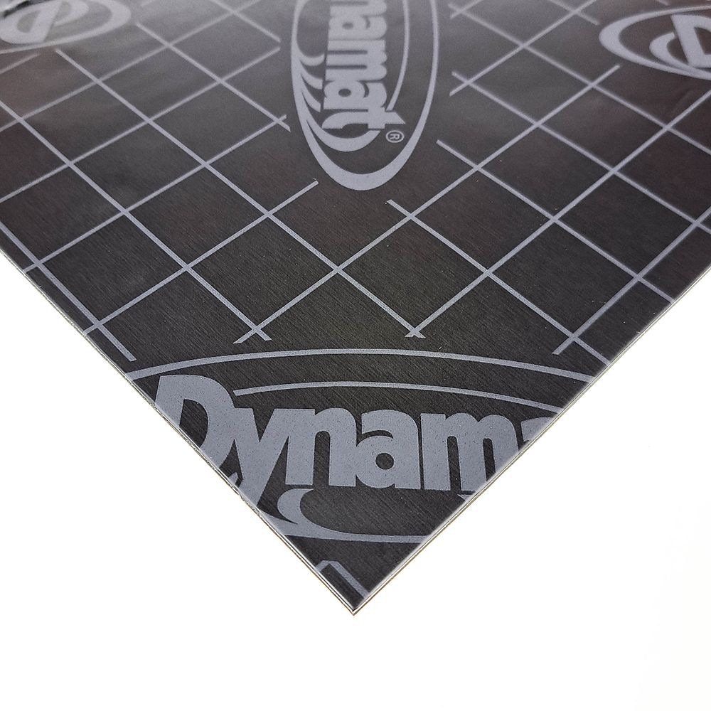 Black cutting mat with grid lines and 'Dynamat' branding on a white background