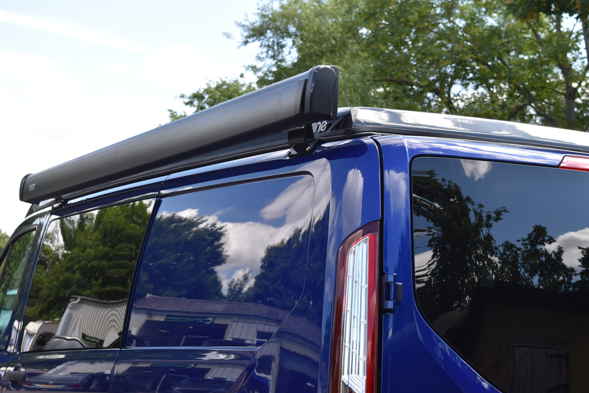 Blue Transit Custom with Skyline pop top roof and Thule wind out awning