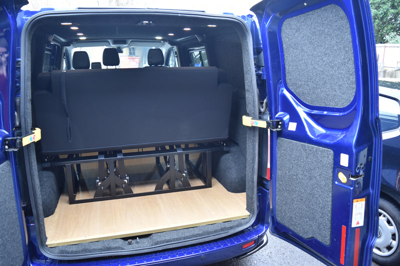 Open blue van with folded black seat/bed.