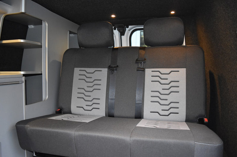 Gray car interior with two seats and a shelf.