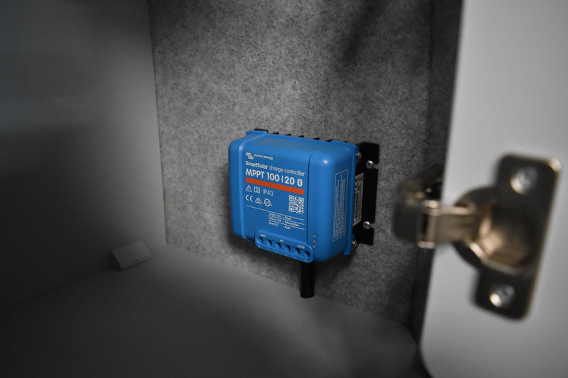 Blue electrical MPPT for solar panel fitted in campervan cupboard
