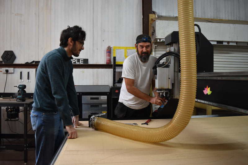 Two men working with in a CNC room.