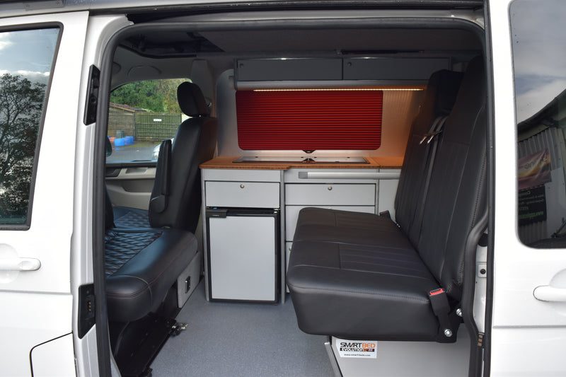 VW Transporter camper with Smart Bed rock n roll bed fitted, plus cabinets to the O/S with red blinds