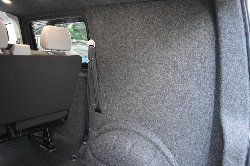Back of a vehicle with gray carpeting and seats