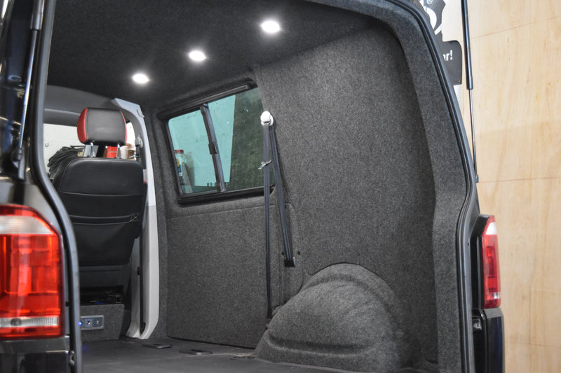 Car interior with carpet lined walls and roof spot lights