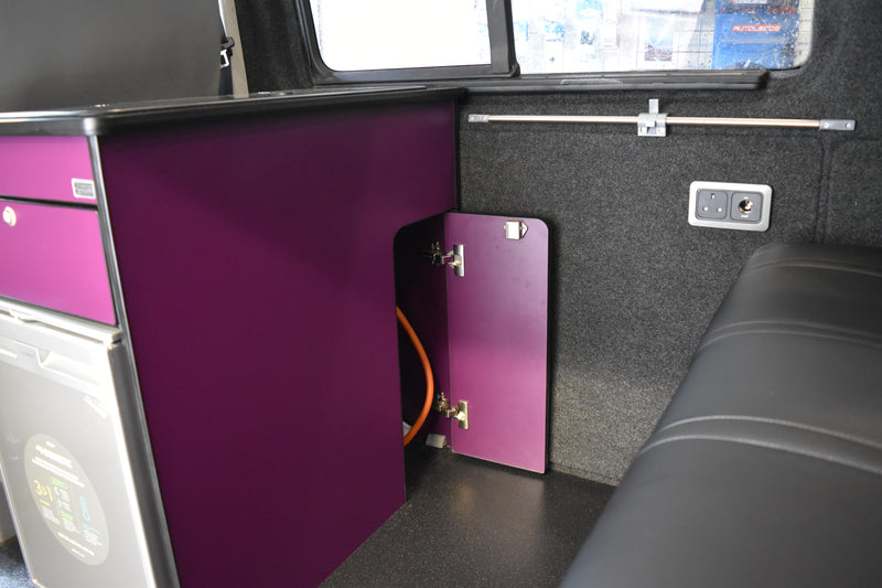 Interior of a vehicle with purple storage compartments and black leatherette seats.