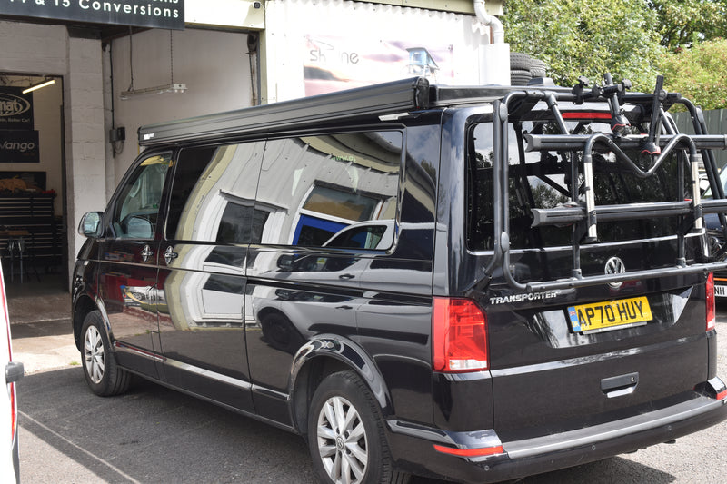 Black VW Transporter van with black bike rack and black Fiamma F45S awning fitted