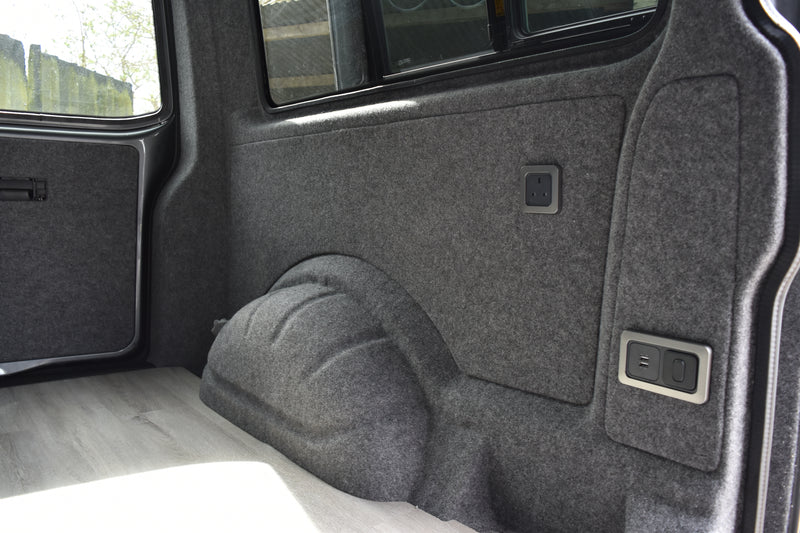 View of a VW Transporter wheel arch carpet lined in grey carpet