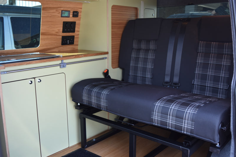 Black and tartan RIB Bed in a campervan with olive and wood units