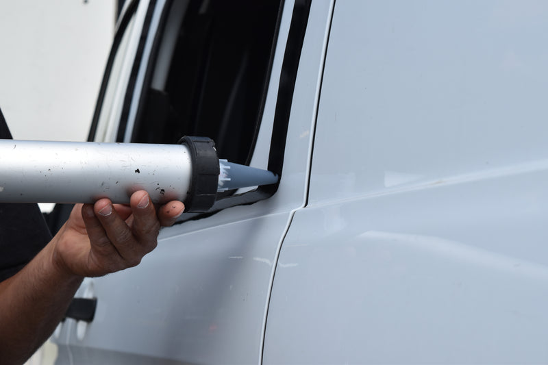 Person using a mastic gun to apply window sealant before window is fitted. 